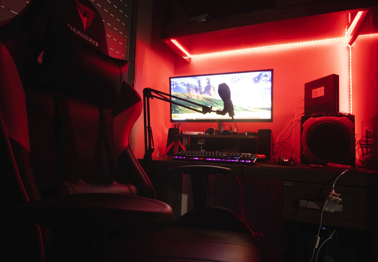 about-us Sleek gaming setup featuring a microphone, neon lights, and a gaming chair in a home studio.